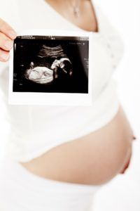 Women's health: pregnancy, birth preparation, pregnant woman with baby photo
