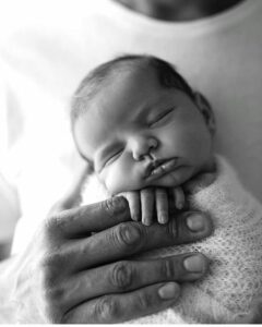 Benefits of Infant/Baby Massage. Baby Sleeping in hands of parent